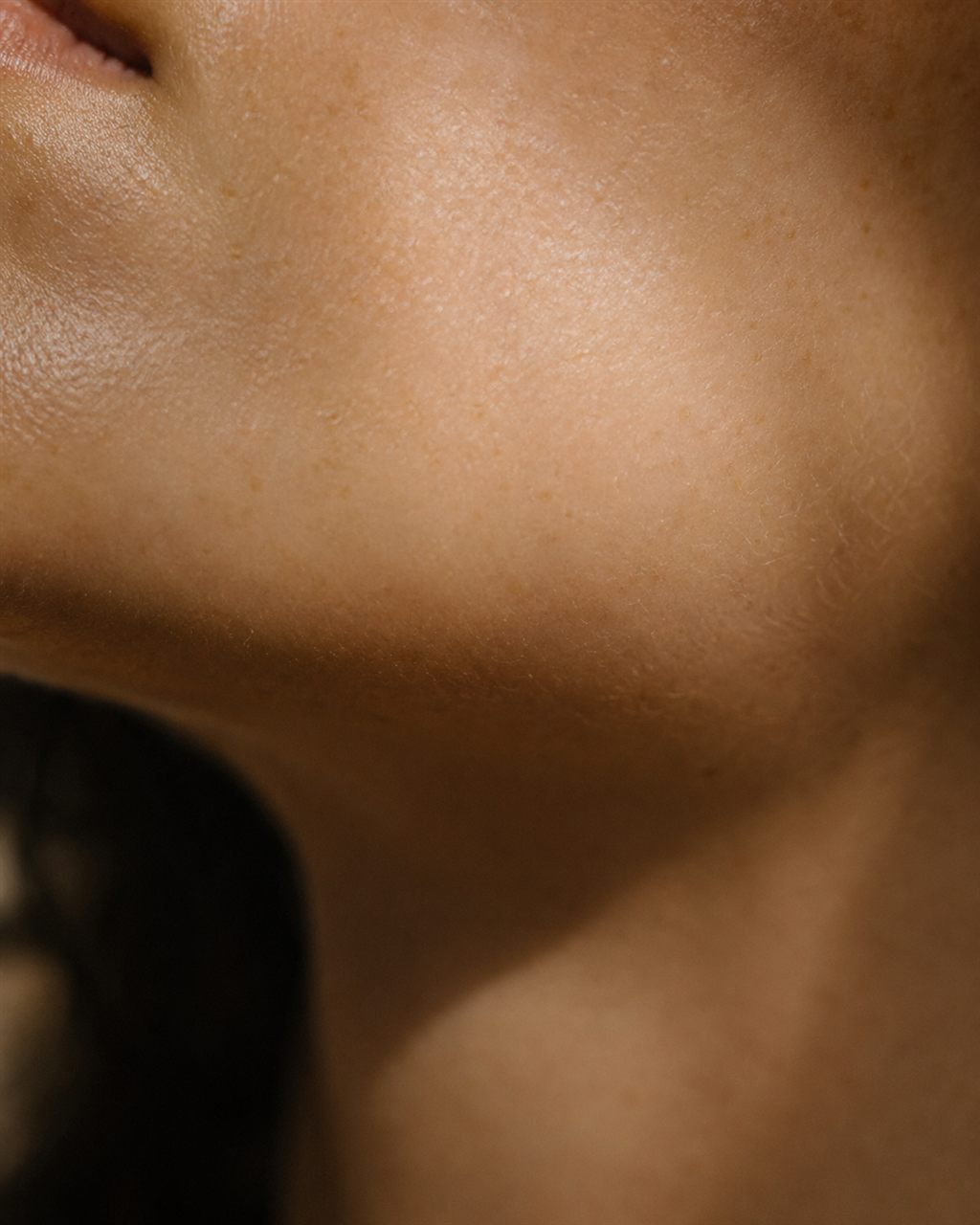 Close view of the skin along a woman's jaw and neck. Illustrative image — not a patient.
