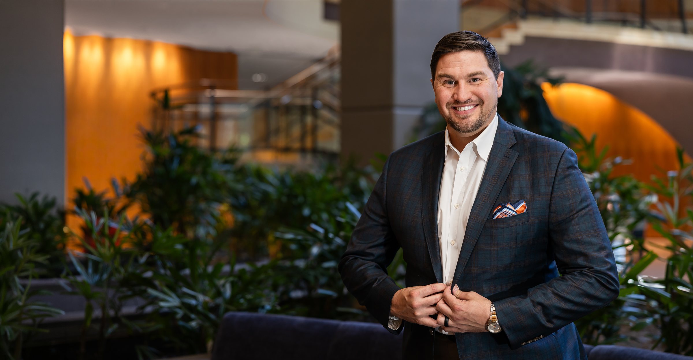 Kristopher M. Day, MD, FACS, standing in the atrium at Pacific Sound Plastic Surgery in Bellevue